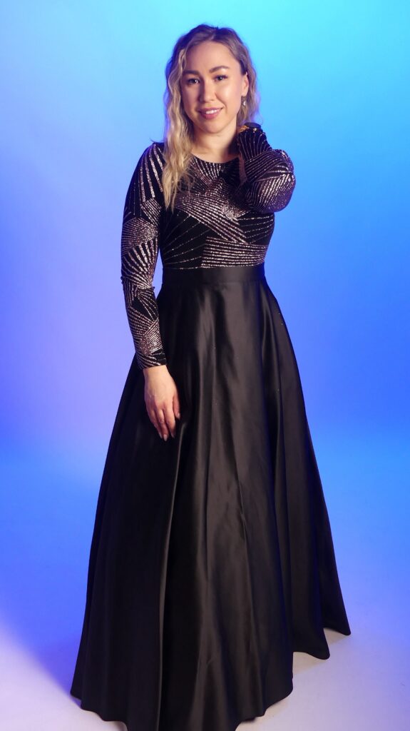 Woman wearing a black long party gown with a stylish shimmer design.