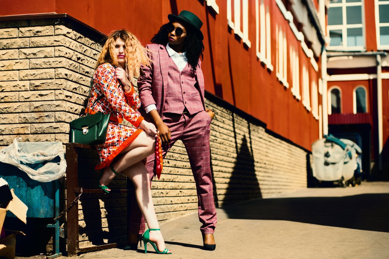My Post Fashionable duo posing outdoors in vibrant outfits, embracing urban style and confidence.